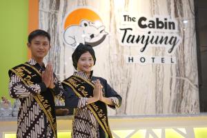 Un uomo e una donna in piedi uno accanto all'altro di The Cabin Tanjung Hotel Wonosobo a Wonosobo