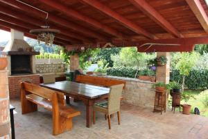 an outdoor patio with a wooden table and a fireplace at Apartment Dragun in Pula