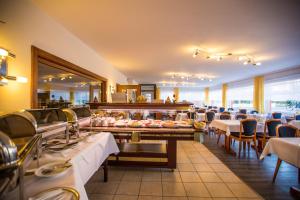 a restaurant with tables and chairs and a buffet at Hotel Graf Waldersee in Borkum
