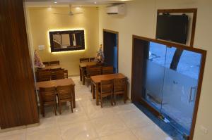 a dining room with tables and chairs and a flat screen tv at Hotel A. K. International - Fort in Mumbai