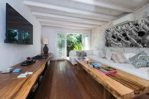 a living room with a white couch and a wooden table at Villa Tranquilla in Nusa Lembongan