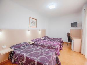a hotel room with two beds and a desk at Hotel Ucanca in Granadilla de Abona