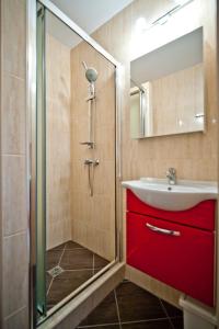 a bathroom with a red sink and a shower at Willa pod Dębem in Rozewie
