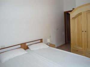 トッレ・ヴァードにあるCasa le Cupe - Gelsoの白いベッドと木製キャビネット付きのベッドルーム1室が備わります。