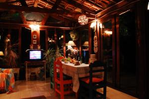 a dining room with a table and a tv at Posada del Bosque in Rivera