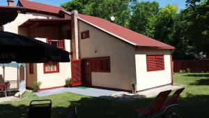 a small house with red shutters on it at Judit nyaraló in Velence