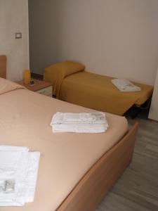 マテーラにあるB&B I Like Materaのホテルルーム内のベッド2台(タオル付)
