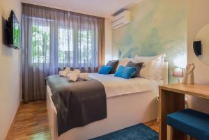 1 dormitorio con 1 cama grande con almohadas azules en Kolombo Lux apartment, en Split