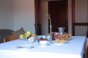 einen Tisch mit Obstschalen auf einem weißen Tischtuch in der Unterkunft Marilide in Marotta