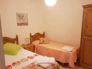 two beds in a small room with two tables at Las Belisas - Apartamentos in Arenal d'en Castell