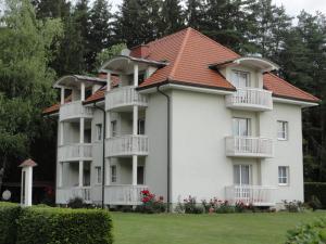 ein großes weißes Gebäude mit rotem Dach in der Unterkunft Ferienwohnung Rogatsch in Sankt Kanzian am Klopeiner See