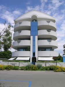 a tall white building with a blue at Residence Terme in Grado