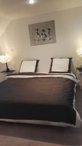 een slaapkamer met een groot bed met 2 lampen bij les Bovrieres in Cysoing