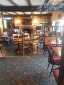 Un comedor con mesas y sillas y una chimenea. en The Dog Inn, en Bristol