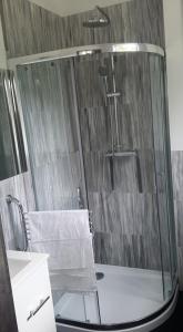 um chuveiro com uma porta de vidro na casa de banho em Domki Heaven Kujanki em Kujanki