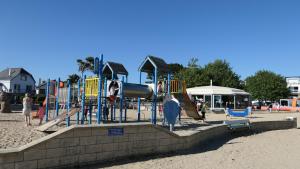 un parque infantil en la playa con gente jugando en él en Villa pecheur, en Damgan