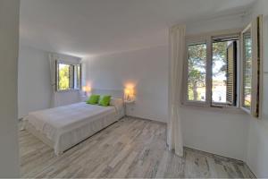 biała sypialnia z łóżkiem i oknem w obiekcie Apartamento Ferrera Park 622 w mieście Cala Ferrera