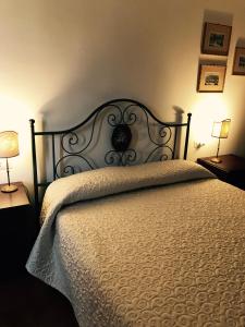 una camera da letto con un letto con un piumone bianco e due lampade di B&B La Dimora del Capitano a Fabriano