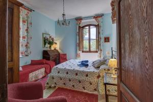 a bedroom with a bed and a chair and a window at La Loggetta - Chianti apartments in Gaiole in Chianti