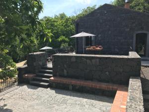 a stone retaining wall with stairs and an umbrella at Rifugio Manfre in Belpasso
