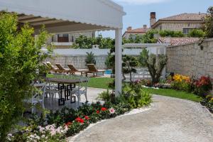 a patio with a table and chairs in a garden at Kokopelli Alacati in Alaçatı