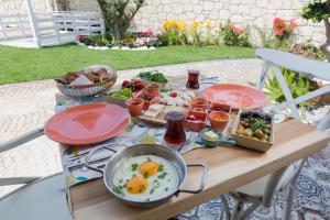 a table with a breakfast of eggs and food on it at Kokopelli Alacati in Alaçatı