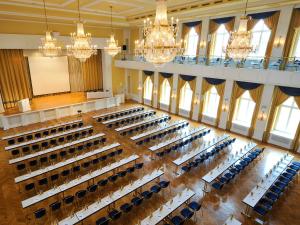 ein leerer Hörsaal mit Stühlen und Kronleuchtern in der Unterkunft DORMERO Hotel Halle in Halle an der Saale