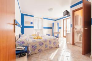 a blue and white bedroom with a bed and a bathroom at Albergo Belvedere in Collio