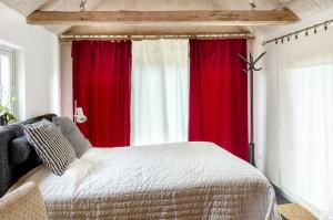 Sankt OlofにあるLitet Gästhus i Sankt Olofの赤と白のカーテンとベッドが備わるベッドルーム1室