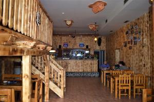 LopejにあるMOTEL ROUTE 66 Lopejの木製の壁とテーブルのあるレストラン、バー