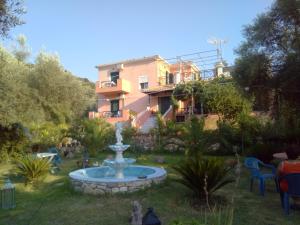 a garden with a fountain in front of a building at Ellis Studios in Meganisi