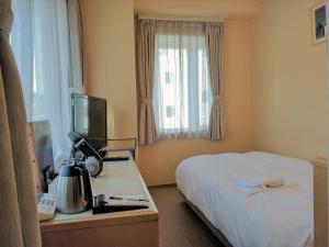 橫須賀的住宿－橫須賀港酒店，酒店客房配有一张床和一张带电脑的书桌