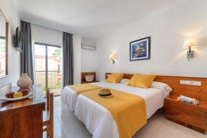 A bed or beds in a room at Aparthotel Vibra Bay