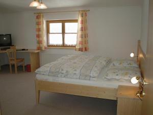 a bedroom with a bed and a desk and a window at Appartement La Piazza in Krimml