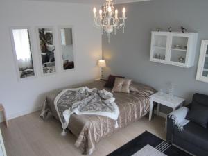 a bedroom with a bed and a couch and a chandelier at Piriko Apartments in Rovaniemi