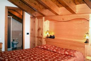 1 dormitorio con 1 cama en una habitación con techos de madera en Hotel Sole, en Castione della Presolana