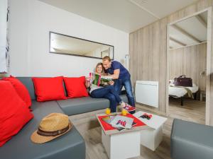 a man and woman sitting on a couch in a living room at Domaine de Blangy in Hirson