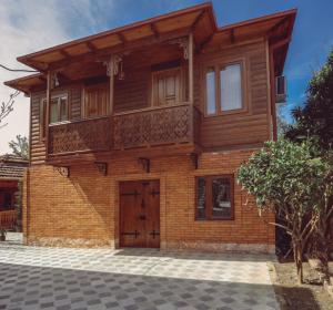 a wooden house with a balcony on top of it at Casa de Khasia in Zugdidi