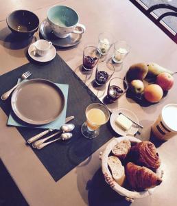 - une table avec des aliments pour le petit-déjeuner et du café dans l'établissement les Bovrieres, à Cysoing