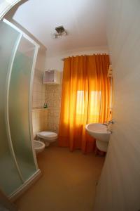 クザーノ・ムトリにあるCusanarella Miaのバスルーム(オレンジ色のシャワーカーテン、トイレ付)