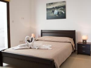 a bedroom with a bed with two swans towels at Valentine's House in Theletra +15 photos