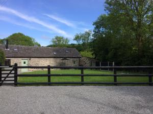 a black fence in front of a stone barn at The Bakery in Llanddeiniol