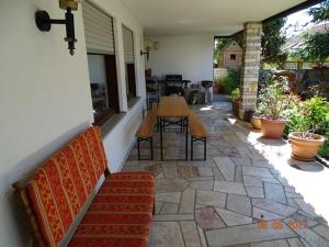 een patio met een bank en een tafel en stoelen bij Ferienwohnung am sonnigen Hang in Riedenburg +8 foto's