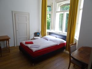 een bed in een kamer met 2 ramen en een tafel bij Villa Bellevue Dresden in Dresden