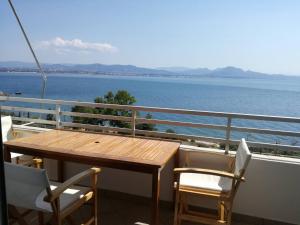 a table and chairs on a balcony overlooking the water at Atlas-Unlimited Sea View Apartment in Loutraki