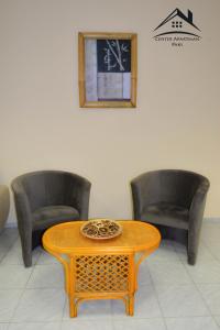 two chairs and a table in a waiting room at Center Apartman - Paks in Paks