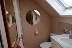 baño con 2 espejos, lavamanos y aseo en Room by the Beach, en Aird Tong