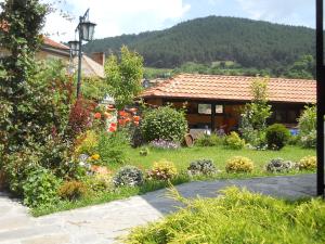 a garden with flowers in front of a house at At Chorbadzhiykata in Kalofer