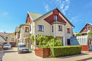 a house with a car parked in a driveway at Holiday house KNP in Palanga