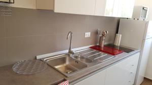 a kitchen counter with a sink and a refrigerator at Case Vacanza Marzano in Monopoli